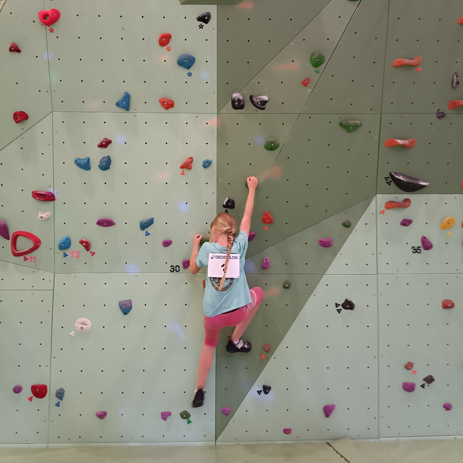 Jeune grimpeuse sur le mur de la Halle Maurice Deley